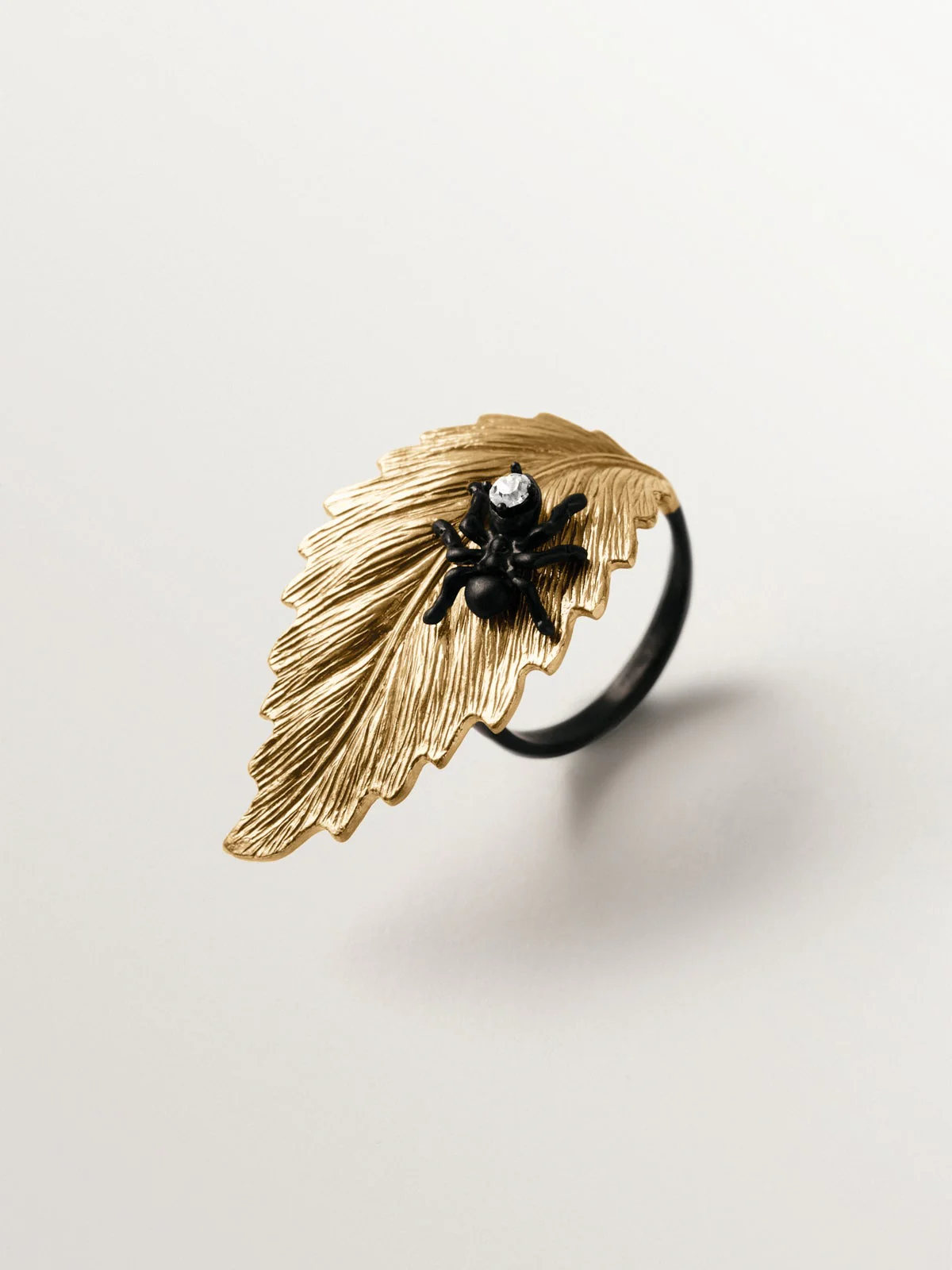 Anillo bañado en oro amarillo con cristales y forma de hoja