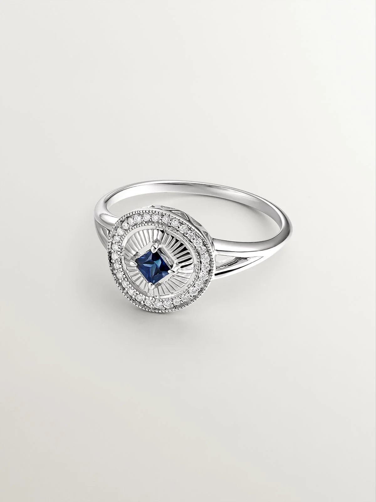 Anillo de oro blanco de 18K con diamantes en talla brillante y zafiro azul en talla princesa - Image 3