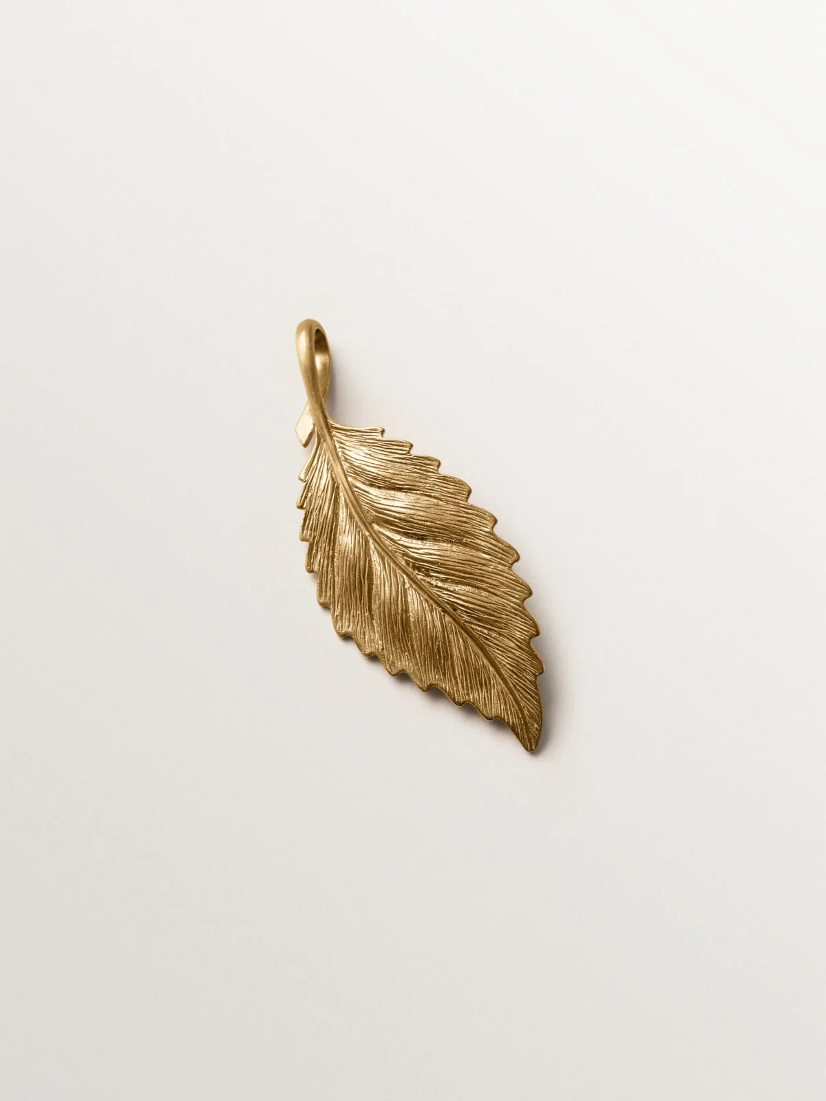 Charm bañado en oro amarillo con forma de hoja
