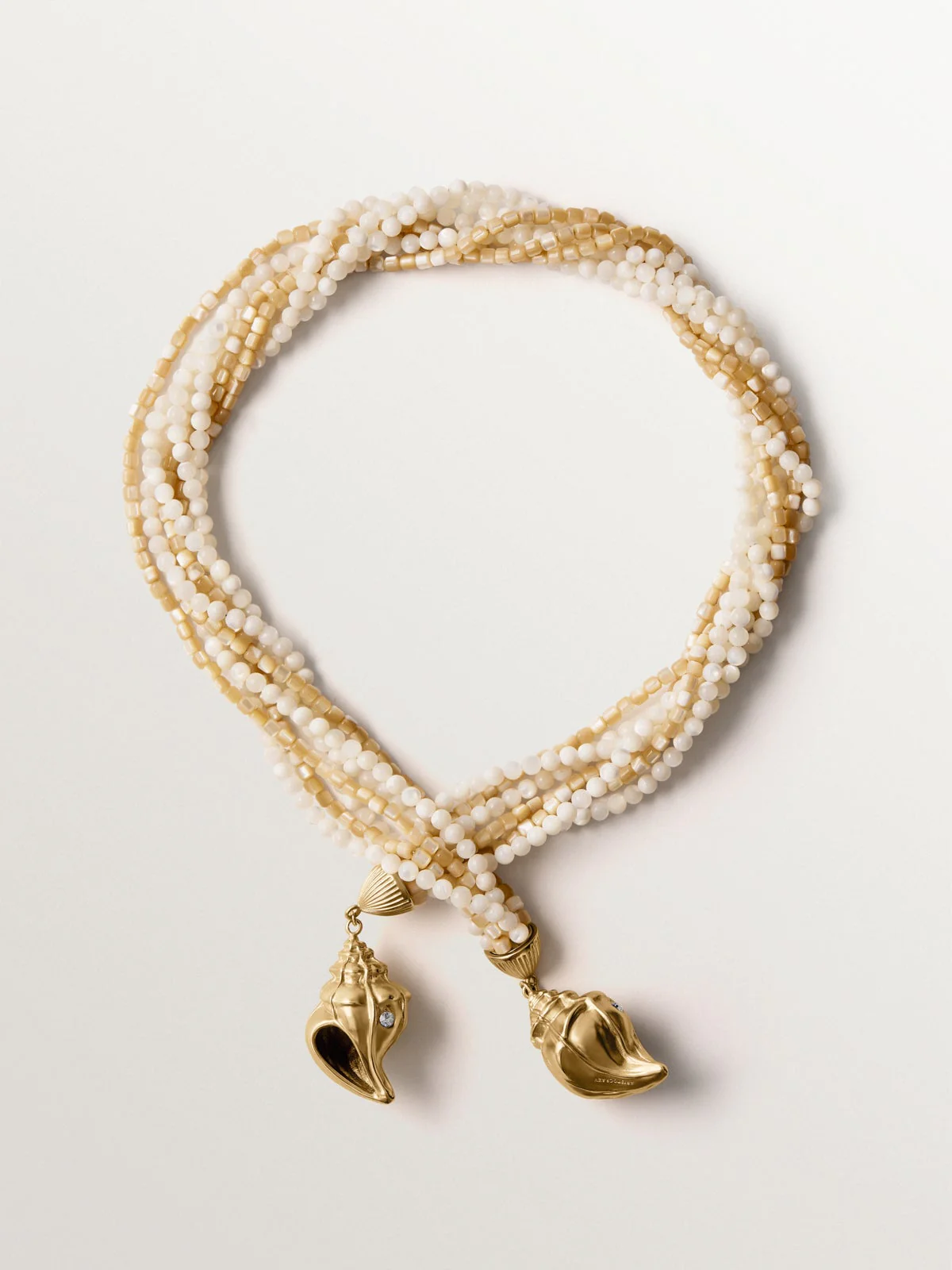 Collar bañado en oro amarillo con bolitas de nácar y forma de concha con cristales
